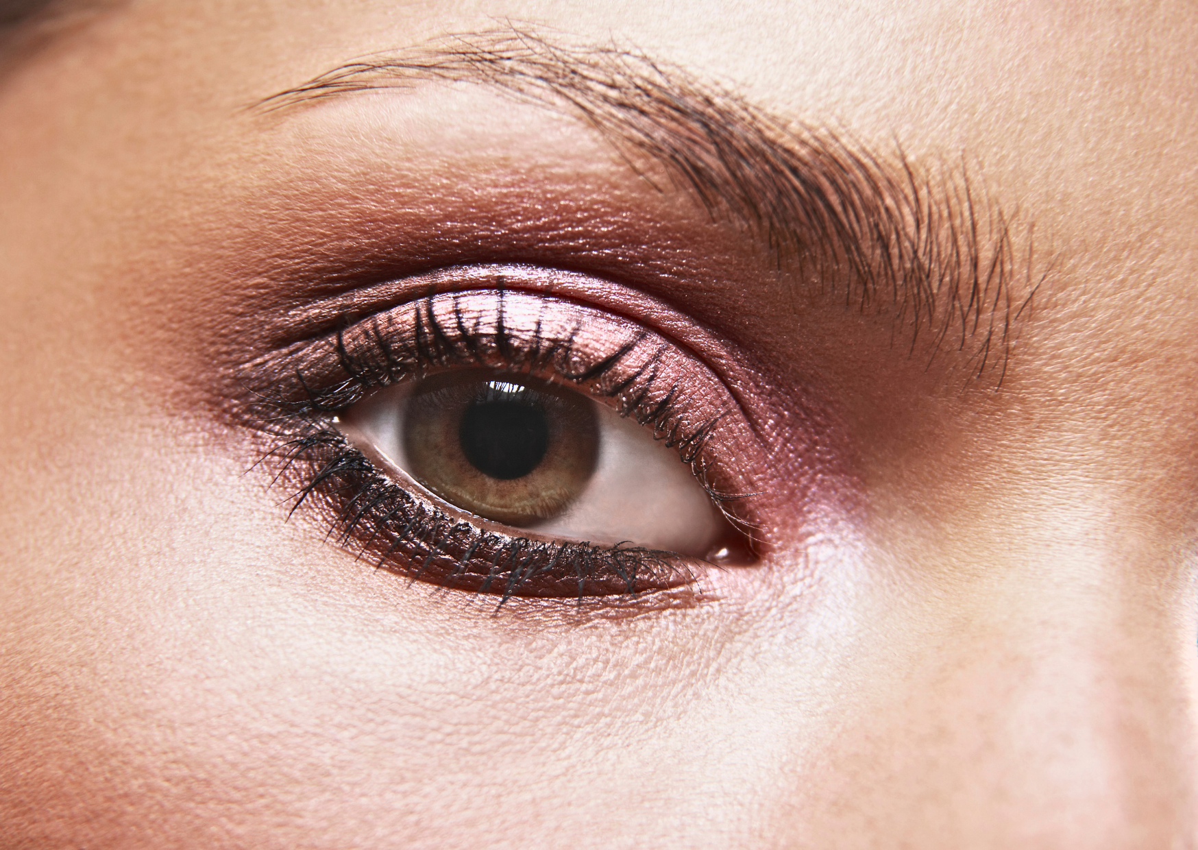 An eye with pink eyeshadow and the inner eye area has been highlighted to enhance her eyes