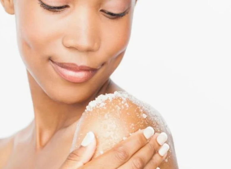 Young woman exfoliating shoulder with homemade sugar scrub for glowing skin and natural beauty