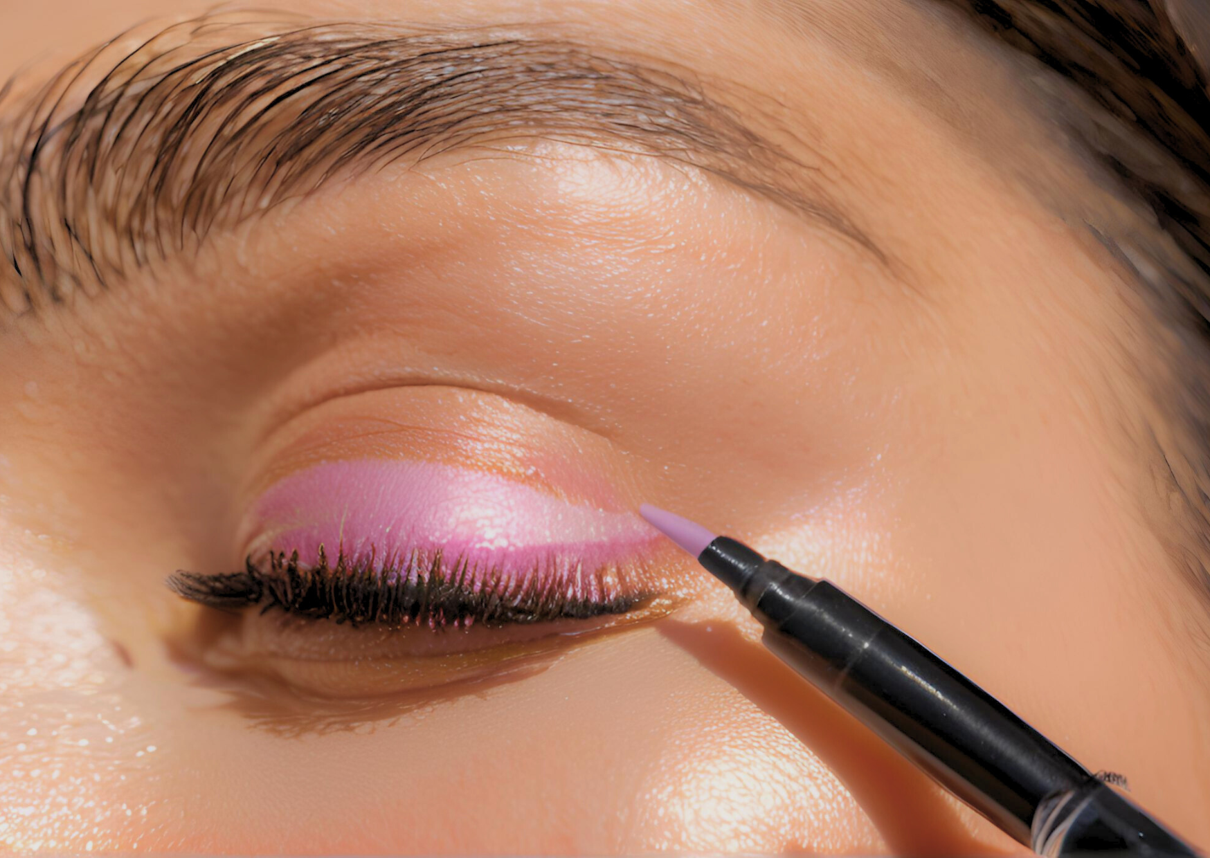 A woman applying bright pink eyeshadow to make her eyes pop and stand out